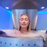 Young woman in a whole body cryotherapy cabin