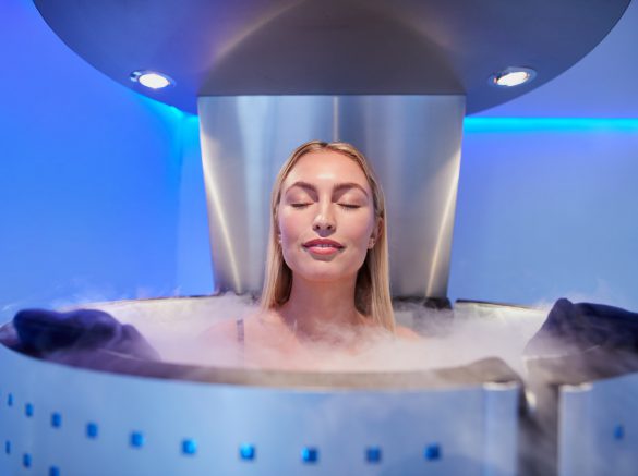 Young woman in a whole body cryotherapy cabin