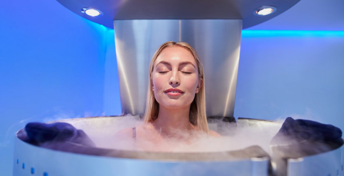 Young woman in a whole body cryotherapy cabin